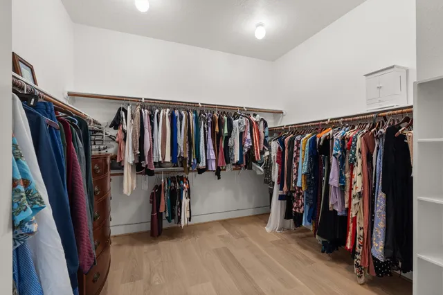 a view of walk in closet with clothes