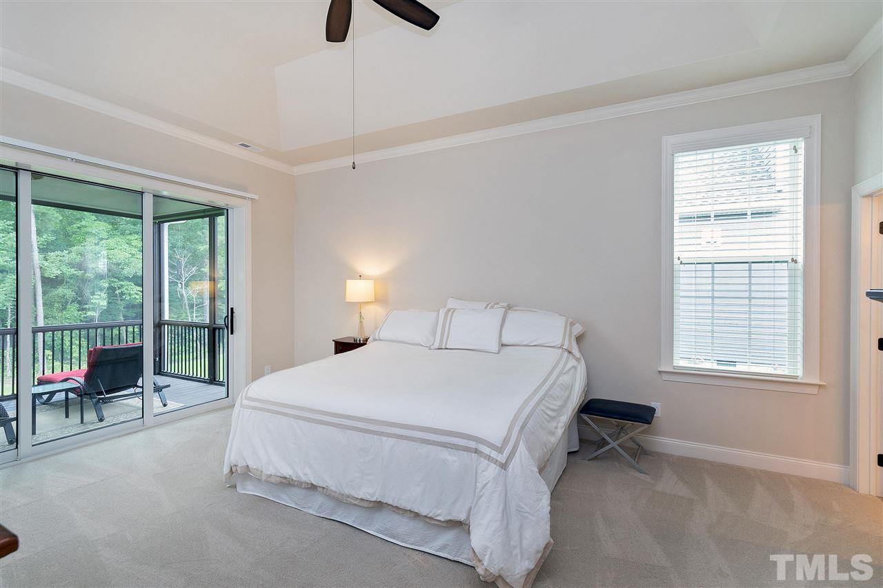 2519 Range Overlook Crossing Apex, NC 27523 - Photo 14 of 26 a spacious bedroom with a bed a table and chair