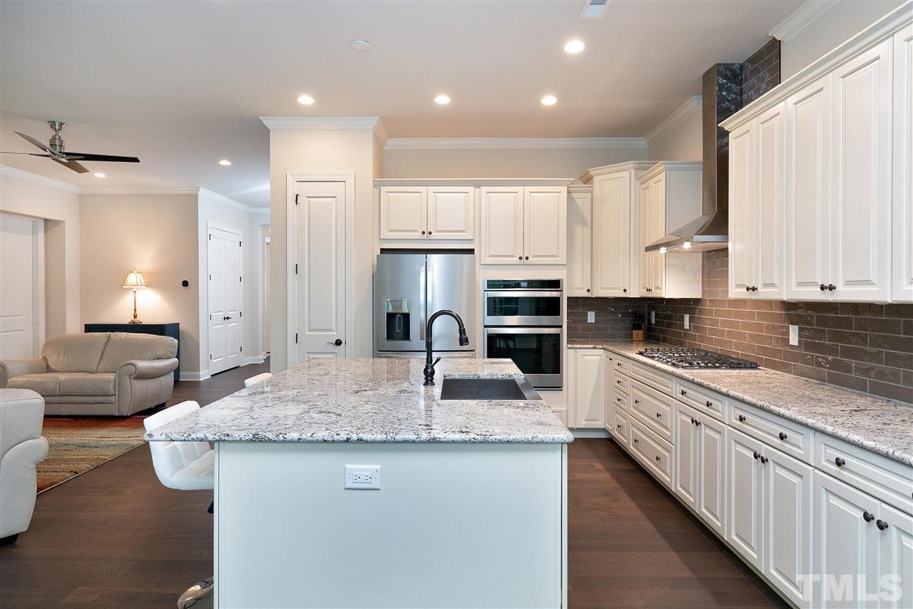 2519 Range Overlook Crossing Apex, NC 27523 - Photo 8 of 26 a kitchen with stainless steel appliances granite countertop a sink stove and refrigerator