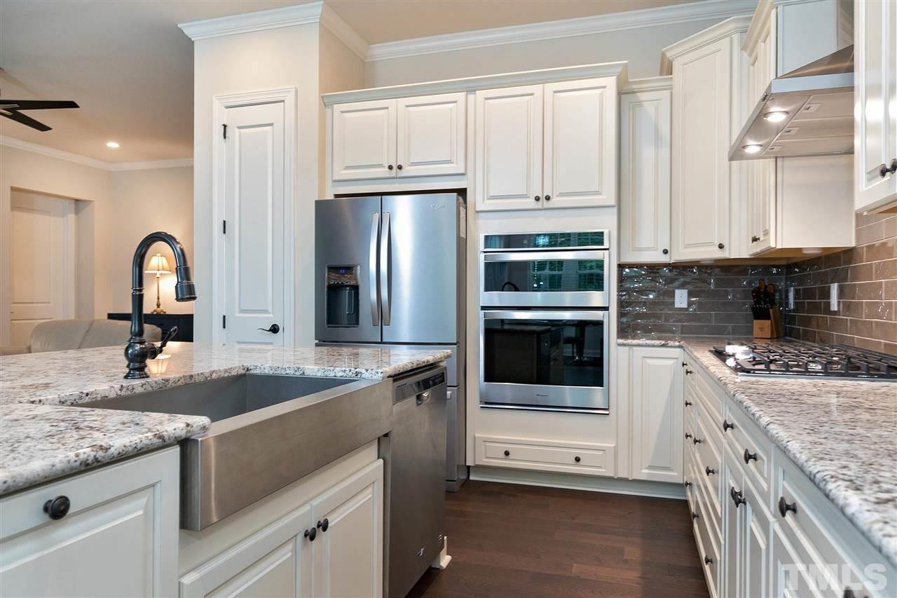 2519 Range Overlook Crossing Apex, NC 27523 - Photo 9 of 26 a kitchen with granite countertop a sink stainless steel appliances and white cabinets