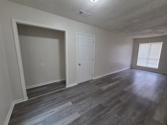 an empty room with wooden floor and closet