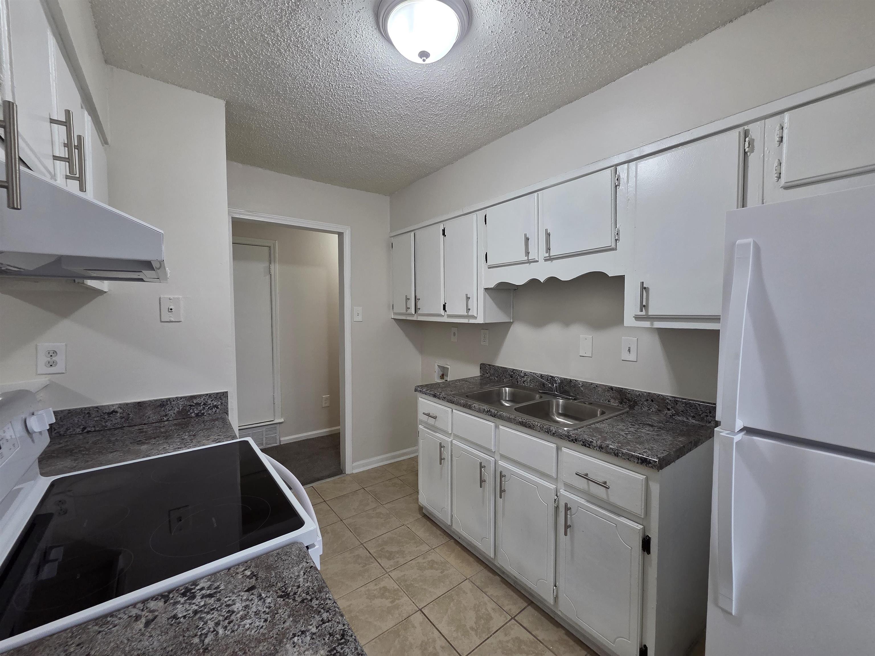 4528 Sugar Creek Road Memphis, TN 38118 - Photo 32 of 40 a kitchen with white cabinets and black appliances