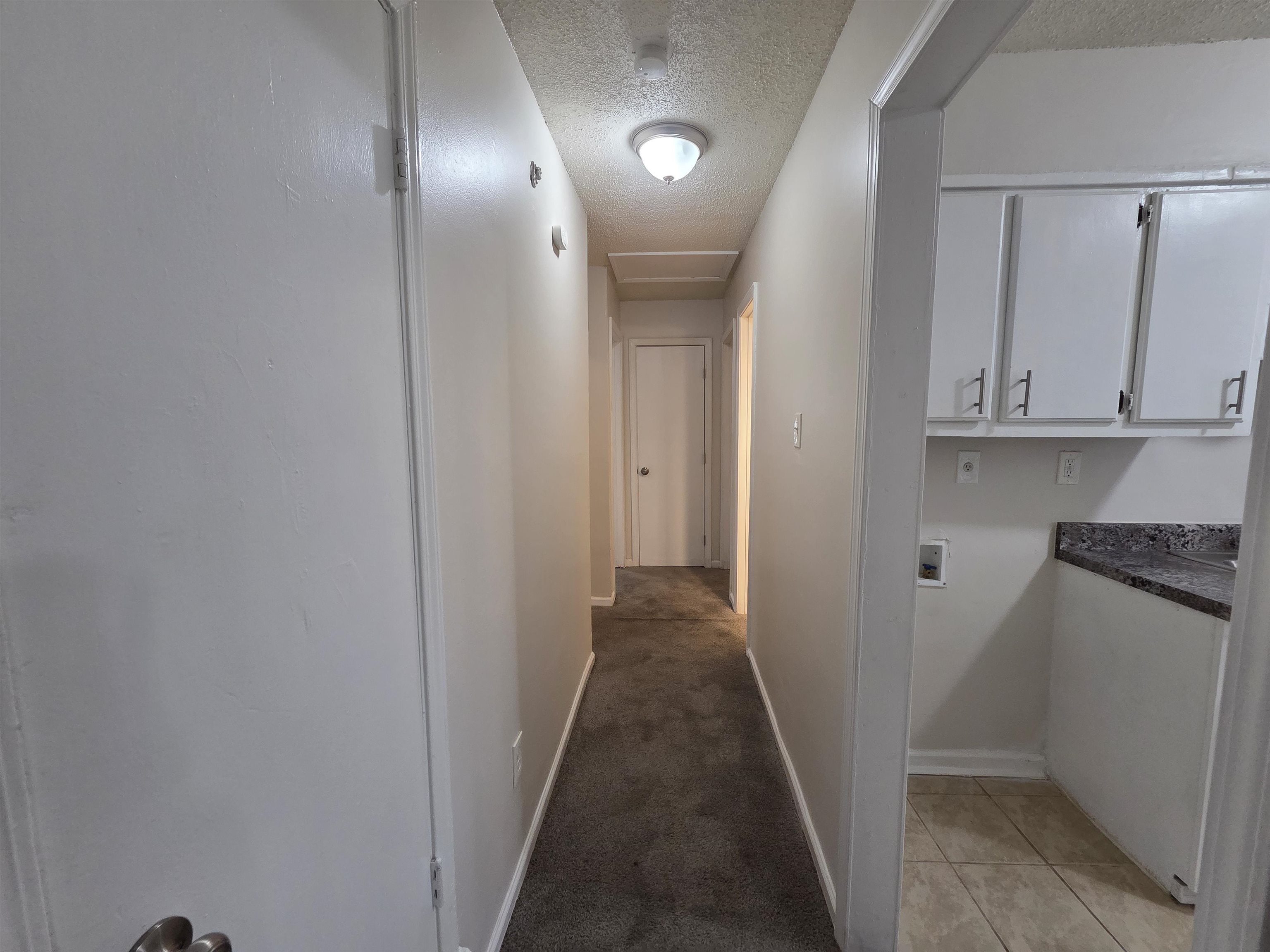 4528 Sugar Creek Road Memphis, TN 38118 - Photo 35 of 40 a view of a hallway with stainless steel appliances granite countertop cabinets and a wooden floor