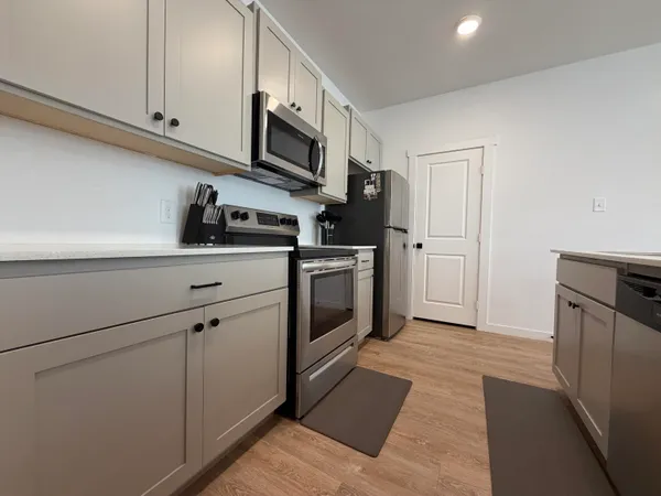a kitchen with stainless steel appliances white cabinets and a stove top oven