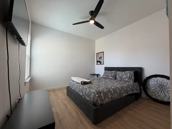a bedroom with bed and wooden floor
