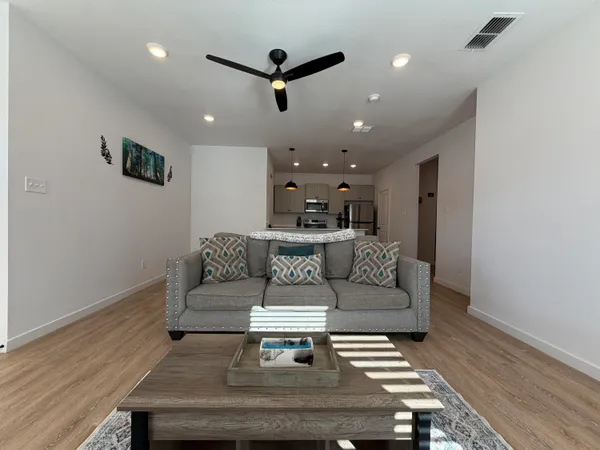 a living room with furniture and a wooden floor