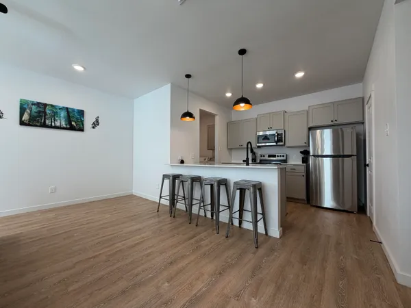 a kitchen with stainless steel appliances granite countertop a refrigerator dining table and chairs