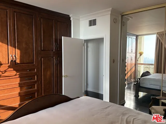 a bedroom with a bed windows and a walk in closet