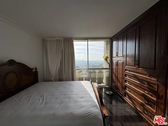 a bedroom with a bed next to a window