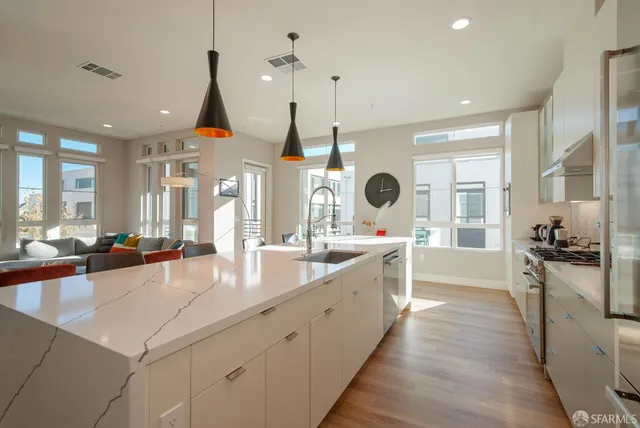 a large kitchen with kitchen island a large counter space a sink appliances and living room view