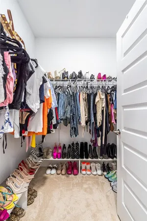 a view of walk in closet with clothes and shoes