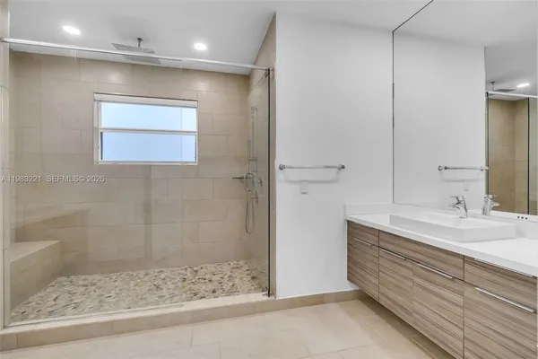 a bathroom with a granite countertop sink mirror and shower