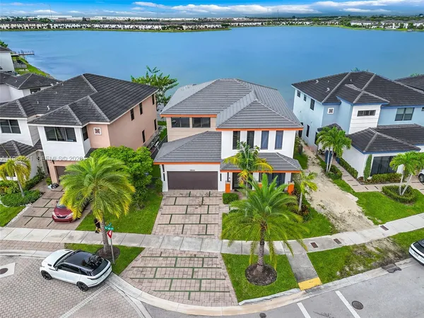 an aerial view of residential houses with outdoor space and parking