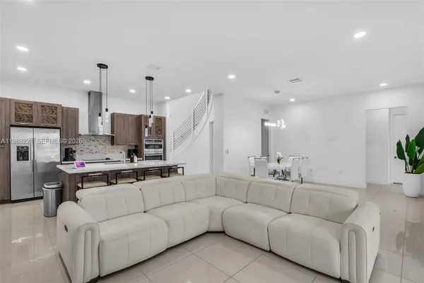 a living room with furniture and a view of kitchen