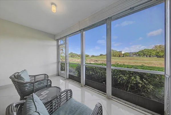 a living room with furniture and a floor to ceiling window