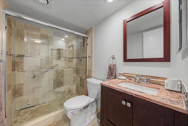 a bathroom with a sink a toilet and shower