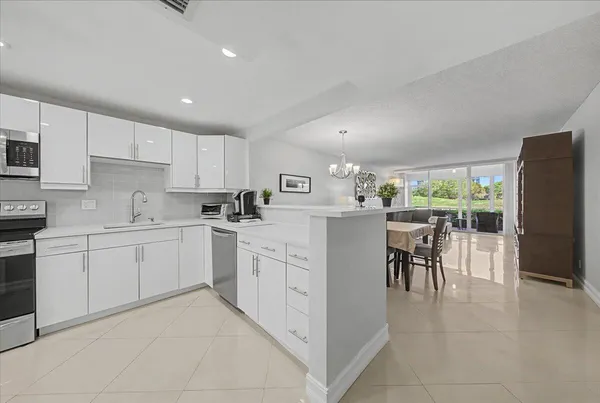 a kitchen with appliances cabinets and chairs