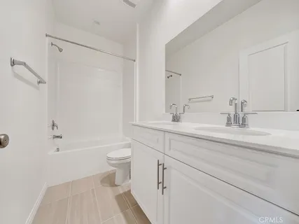 a bathroom with a double vanity sink toilet and shower