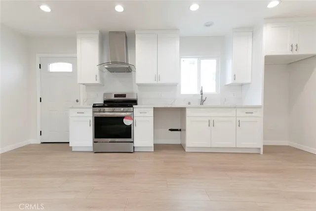 a kitchen with granite countertop white cabinets and stainless steel appliances