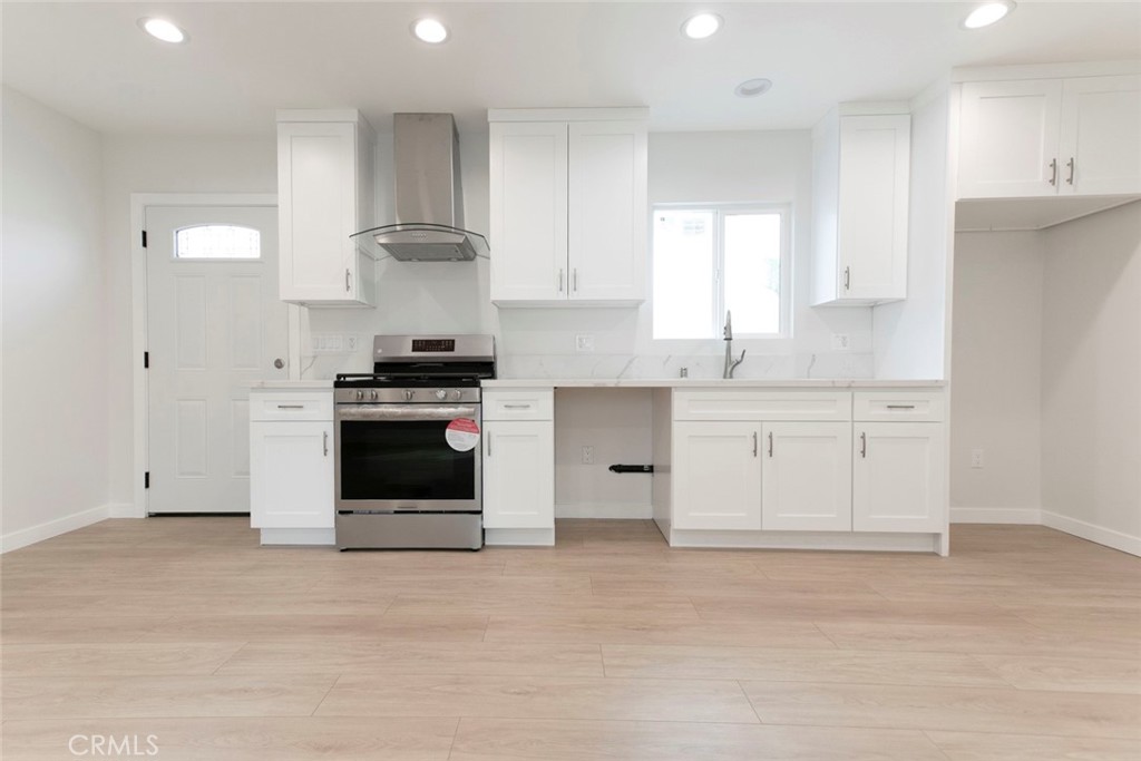 a kitchen with granite countertop white cabinets and stainless steel appliances