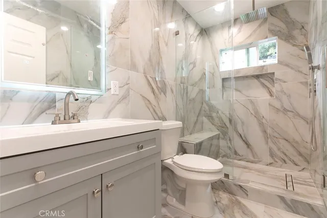 a bathroom with a sink a toilet and shower