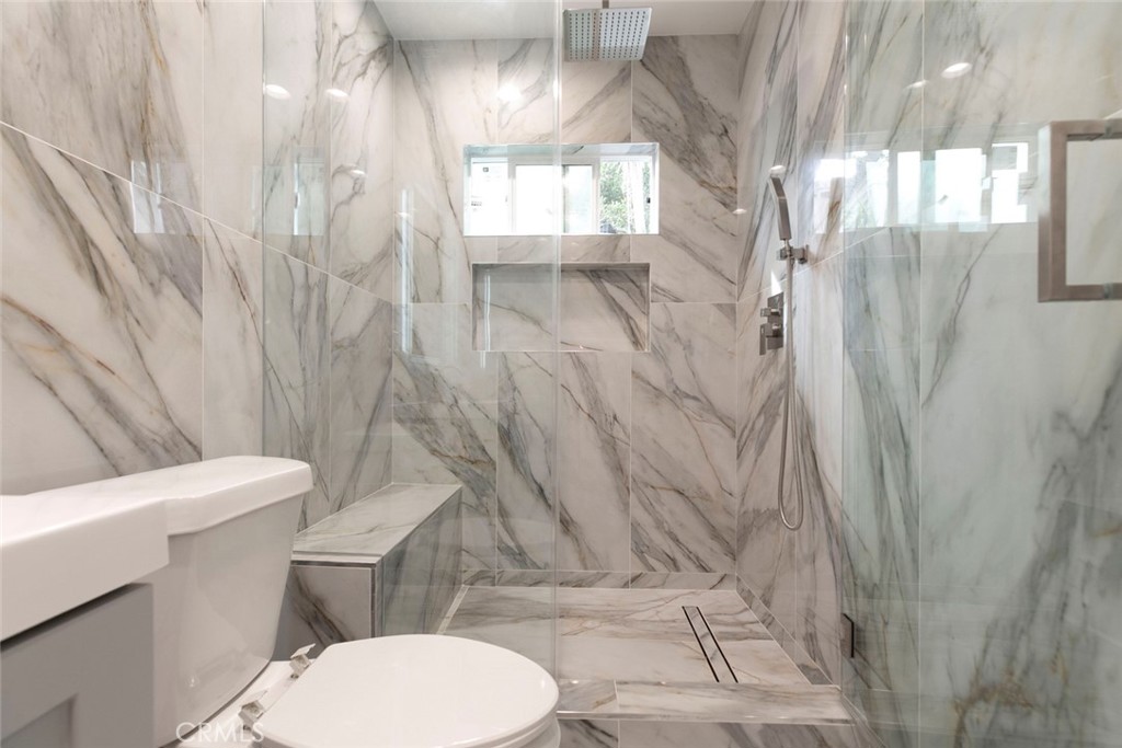 13120 Branford Street Arleta, CA 91331 - Photo 12 of 16 a white toilet sitting next to a shower curtain