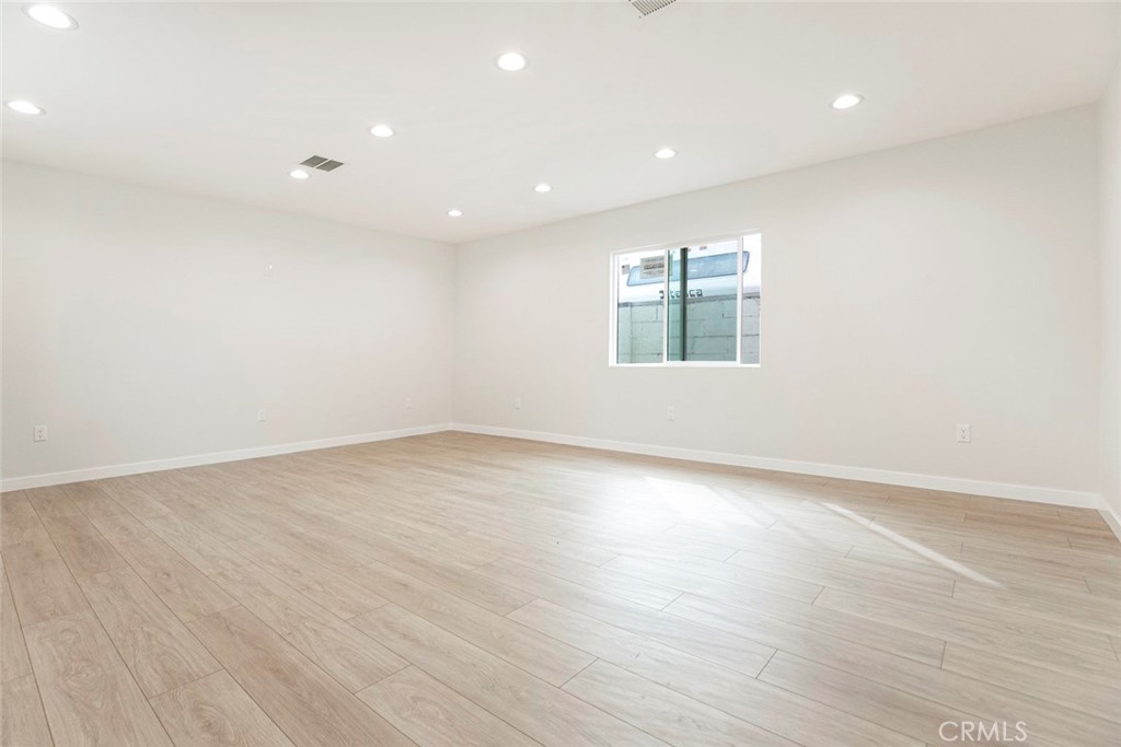 13120 Branford Street Arleta, CA 91331 - Photo 3 of 16 an empty room with wooden floor and windows