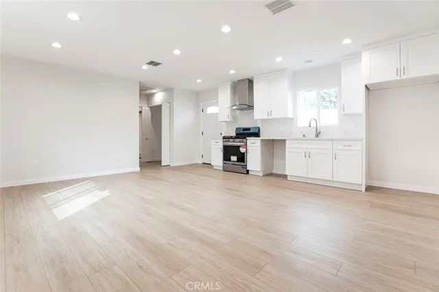 a large kitchen with stainless steel appliances granite countertop a stove a sink and a refrigerator