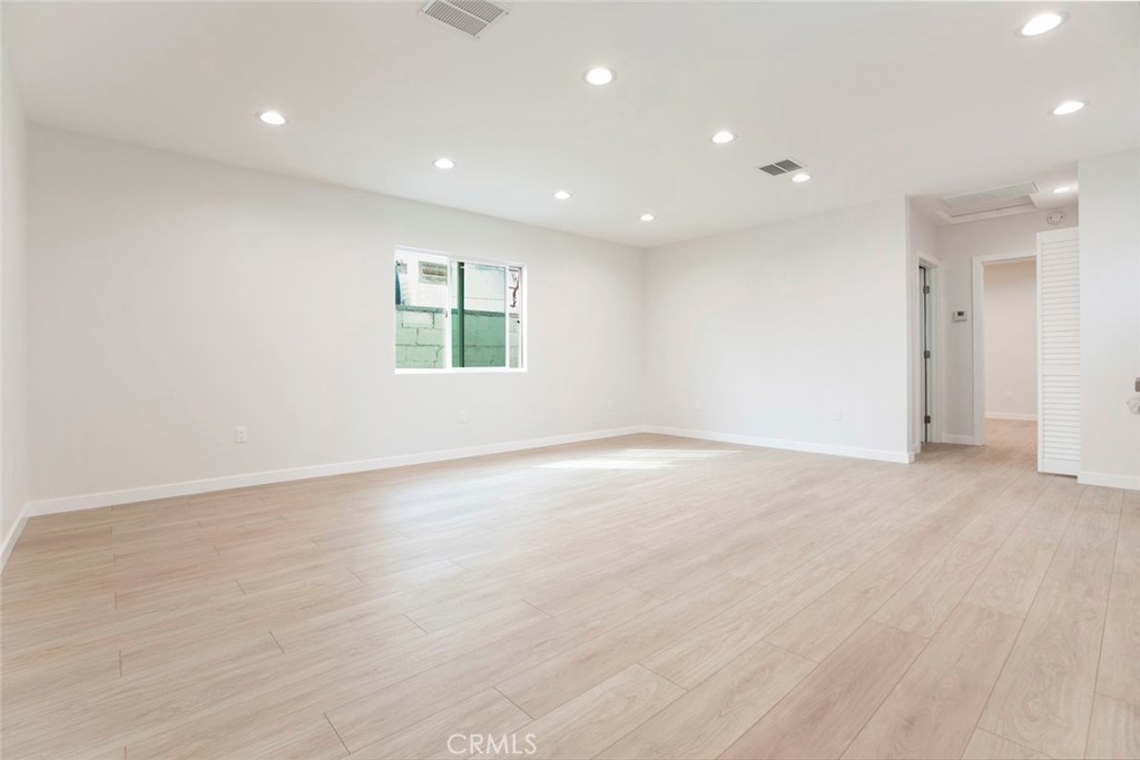 13120 Branford Street Arleta, CA 91331 - Photo 5 of 16 an empty room with wooden floor and windows