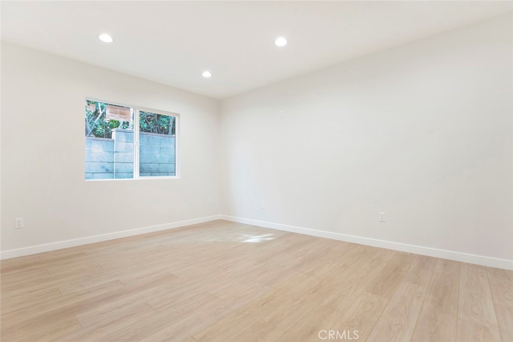 13120 Branford Street Arleta, CA 91331 - Photo 8 of 16 an empty room with wooden floor and windows