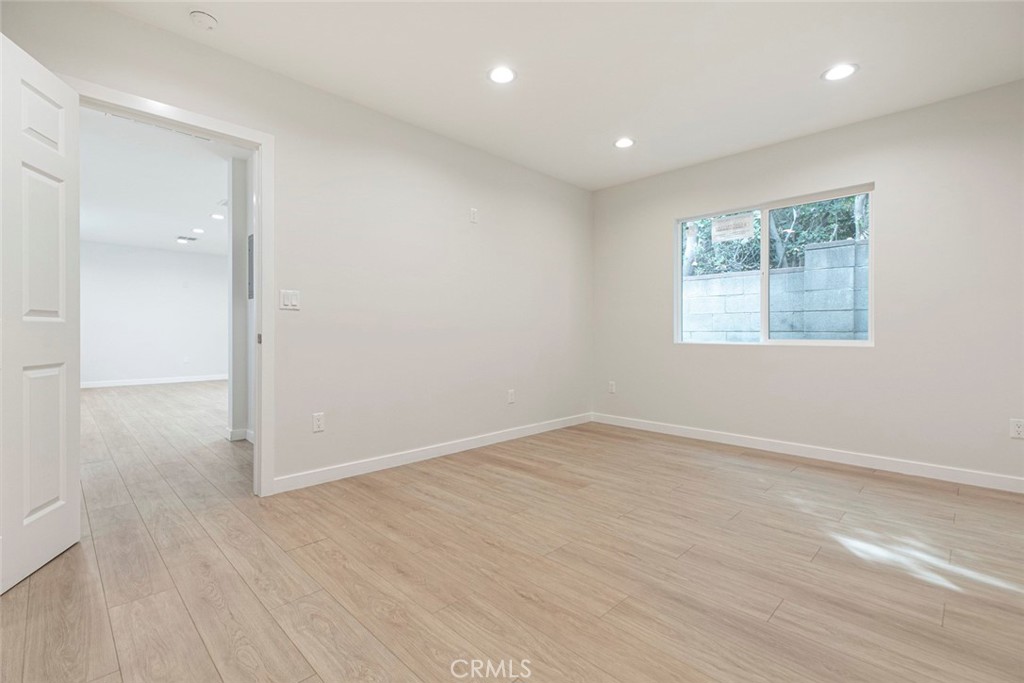 13120 Branford Street Arleta, CA 91331 - Photo 10 of 16 an empty room with wooden floor and windows