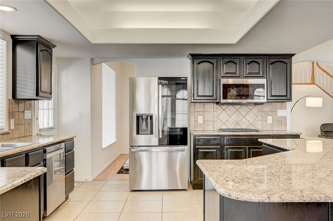2955 El Camino Road Las Vegas, NV 89146 - Photo 2 of 99 Kitchen featuring backsplash, appliances with stainless steel finishes, and arched walkways