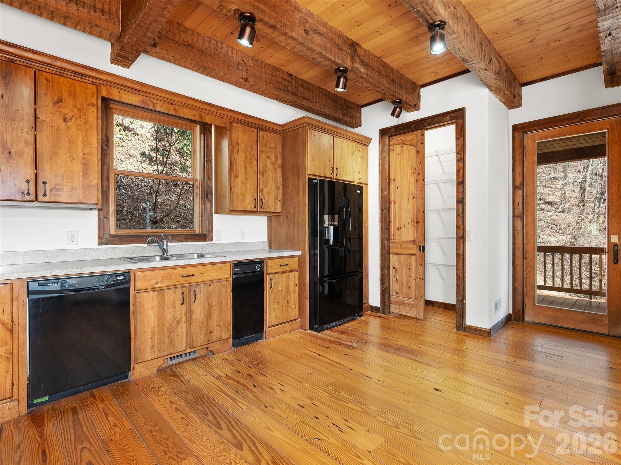 173 Heavenview Point Maggie Valley, NC 28751 - Photo 18 of 47 a kitchen with stainless steel appliances granite countertop a refrigerator a sink dishwasher a stove and white countertops with wooden floor
