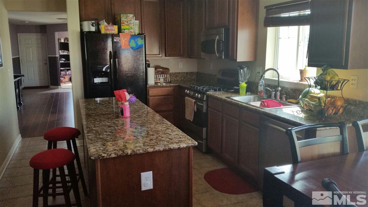 9172 Gilvarry Street Reno, NV 89506 - Photo 1 of 1 a kitchen with stainless steel appliances granite countertop a sink dishwasher and cabinets with wooden floor