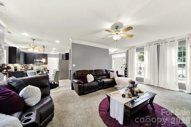a living room with furniture ceiling fan and a window