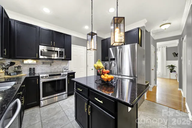 a kitchen with kitchen island a counter space stainless steel appliances and cabinets