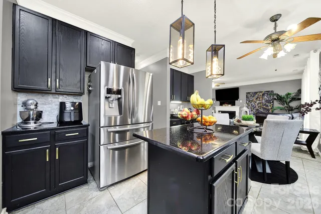 a kitchen with stainless steel appliances granite countertop a refrigerator a stove a sink dishwasher and a refrigerator with wooden cabinets