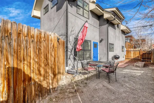 a view of backyard with a table and chairs and wooden fence