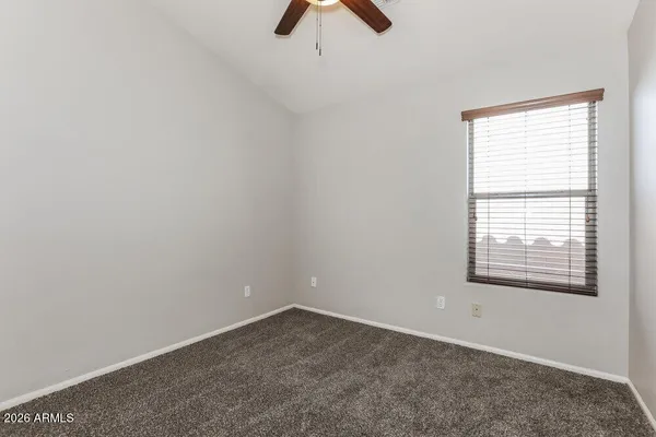 an empty room with a window and a fan