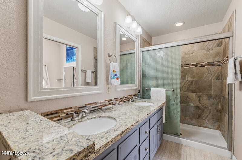 675 College Drive Reno, NV 89503 - Photo 20 of 30 a bathroom with a granite countertop sink mirror and shower