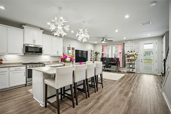 a kitchen with stainless steel appliances a dining table chairs microwave and cabinets