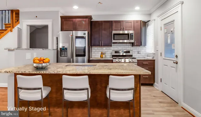 a kitchen with stainless steel appliances granite countertop a sink and a refrigerator
