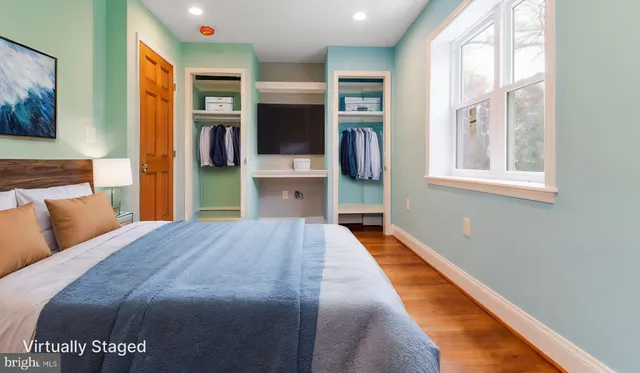 a bedroom with a large bed and a flat tv screen on dresser
