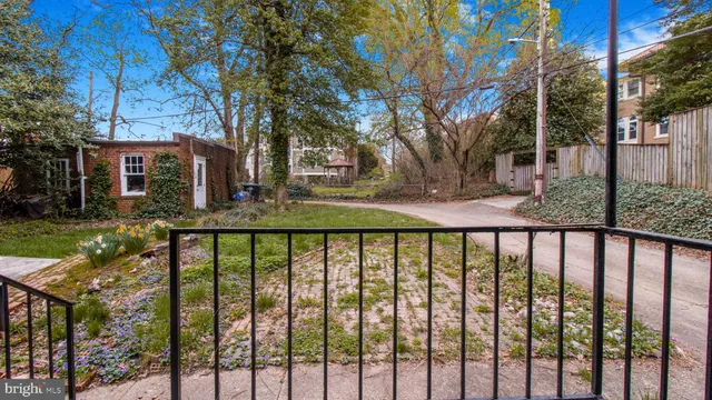 a view of a brick house with large trees next to a yard