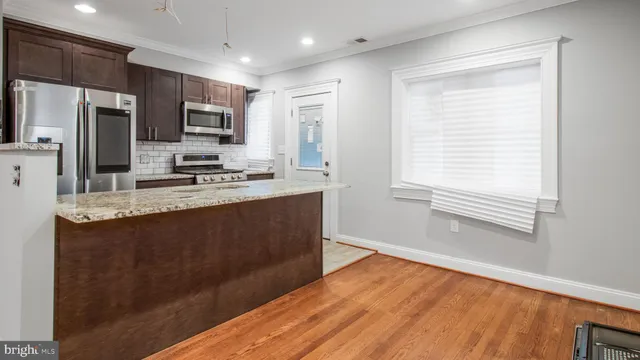 a kitchen with stainless steel appliances granite countertop a stove a sink and a refrigerator