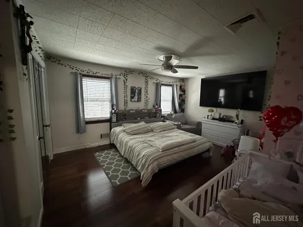 a bedroom with a bed window and flat screen tv