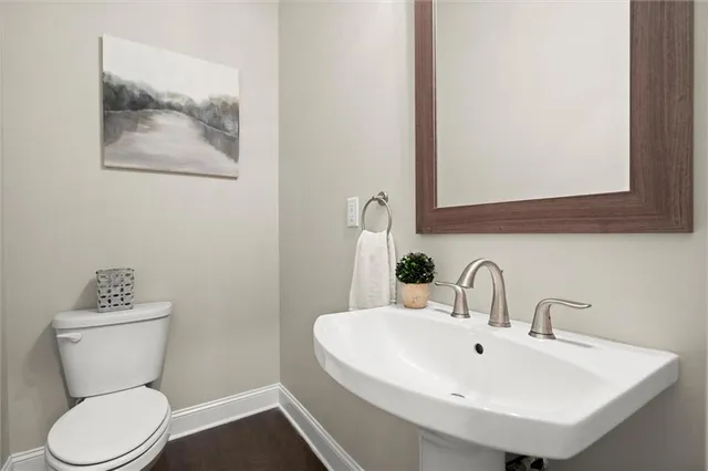 a bathroom with a toilet a sink and mirror