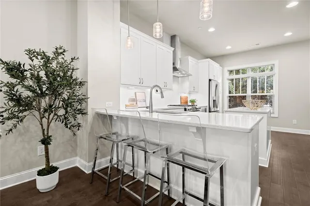 a kitchen with kitchen island granite countertop a table chairs sink and cabinets