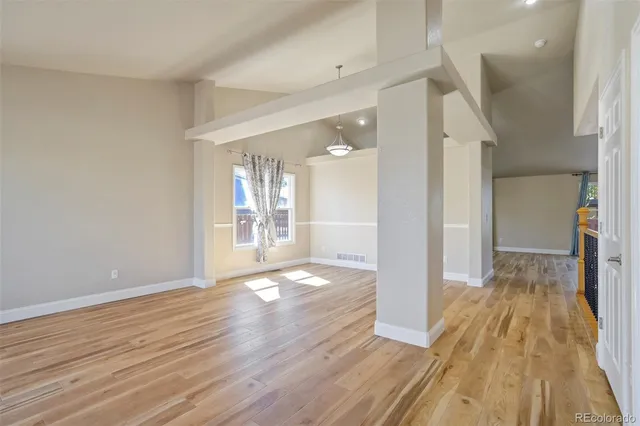 a view of a big room with wooden floor and a bathroom
