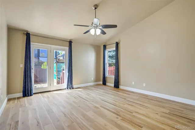 a view of an empty room with window and wooden floor